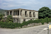 Përmet - verlassener Wohnsitz mit Palmen und grün bewachsener Mauer